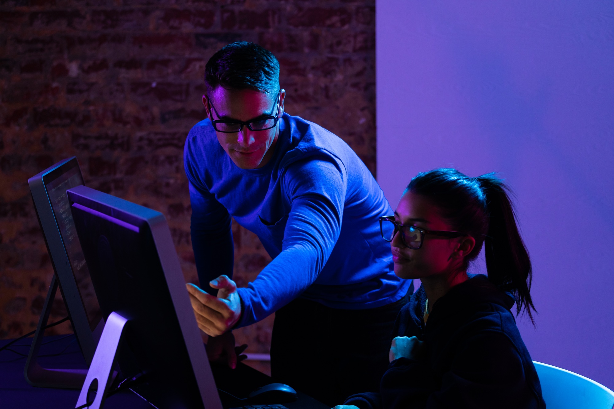 Caucasian man and a mixed race woman working late in a customer support office